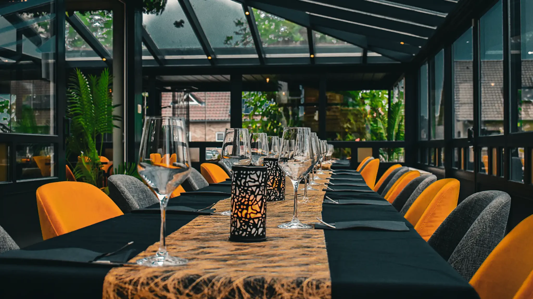 Veranda met lange tafels bij Happy Days, ideaal voor een feestje of als restaurant voor grote groepen. Brasserie Happy Days in Pelt